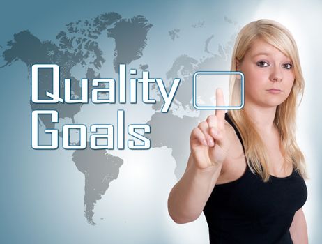 Young woman press digital Quality Goals button on interface in front of her