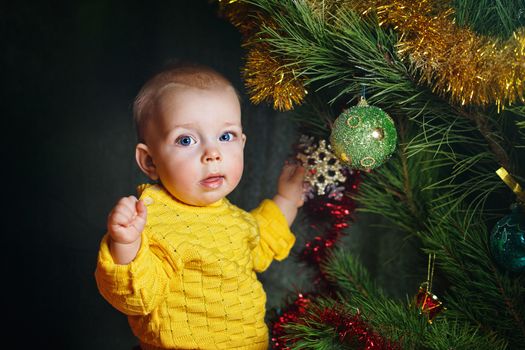 Blue-eyed little girl dresses up Christmas tree