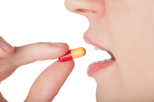 Woman taking a pill isolated over white background