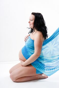 Pregnant young woman with a big belly. sitting in profile