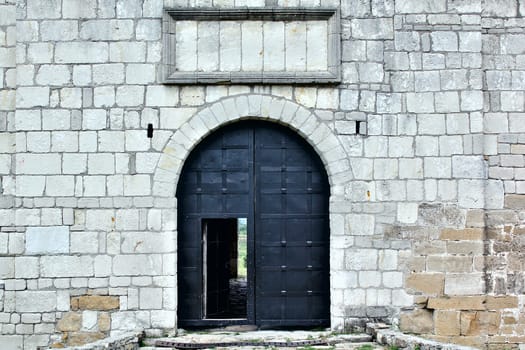 Big iron gates with opened door in the castle