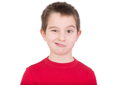 Cute playful young boy in a colourful red t-shirt standing winking at the camera, head and shoulders portrait isolated on white