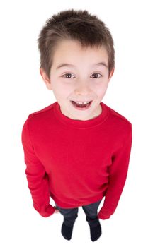 Fun portrait of a laughing young boy looking up at the camera taken full length from a high angle perspective isolated on white