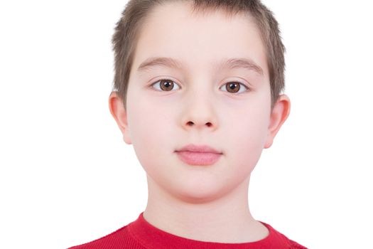 Handsome young boy with a serious thoughtful expression and wide sincere eyes looking directly into the camera, close up facial portrait isolated on white