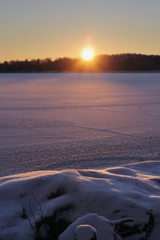 Sunset on frozen lake, winter season concept