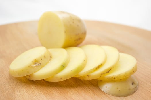 Sliced potato on a wooden cutting board.