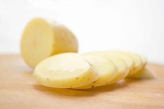 Sliced potato on a wooden cutting board.