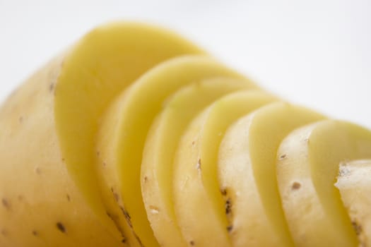 Sliced potato on a wooden cutting board.