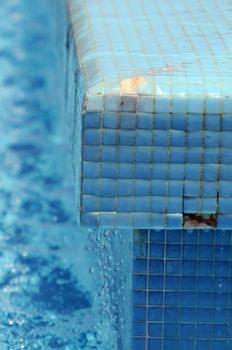 Some Water Dropping off a Blue Swimming Pool