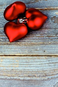 Bunch of Three Red Plastic Hearts closeup on Rustic Wood background