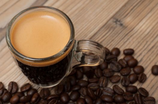 Glass Cup of Espresso Coffee on Wooden Table With Coffee Beans - Shallow Depth of Field
