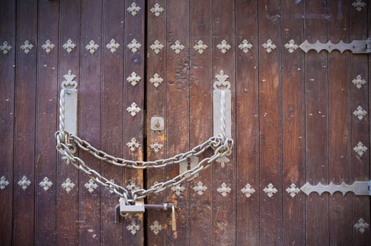 Full frame take of an old door locked with a chain