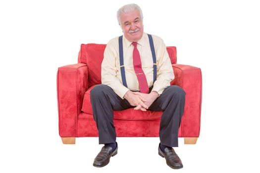 Studio portrait over white of a senior white haired man relaxing in a comfortable red armchair.