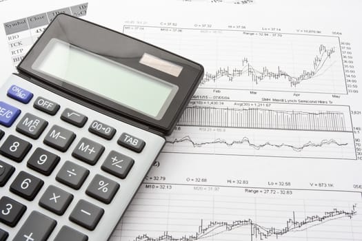 Close-up photo of business objects: calculator and diagrams