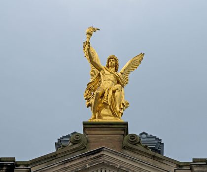Sitting golden angel on the top of historic house in Dresden
