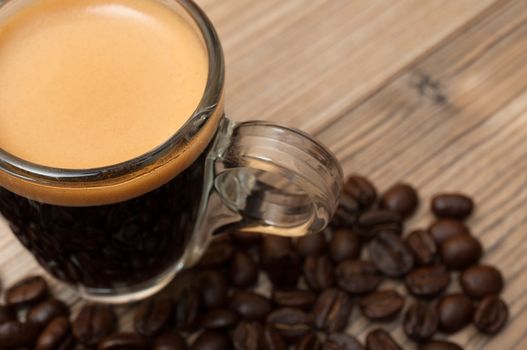 Glass Cup of Espresso Coffee on Wooden Table With Coffee Beans - Shallow Depth of Field