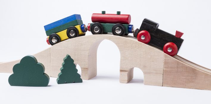 wooden toy train on bridge in grey background. horizontal image