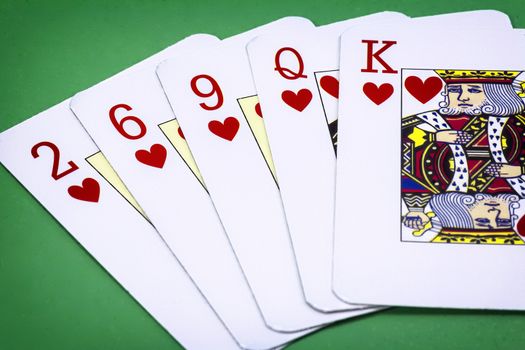 cards poker deck English, Poker hand call color, consisting of five letters of hearts, two of hearts, six of hearts, nine of hearts lady and king of hearts on green background