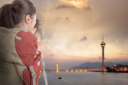 Young backpacker travel and take picture at Macau with famous travel tower.