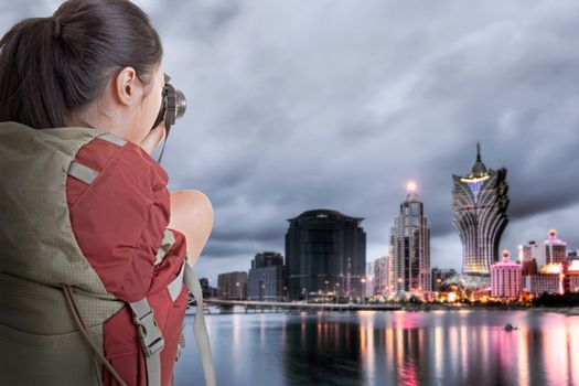 Young backpacker travel and take picture at Macau with famous casino skyscrapers.