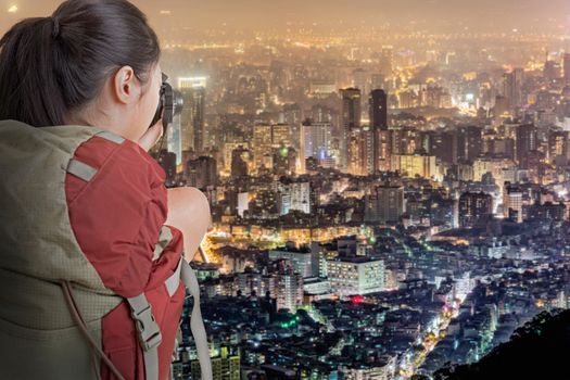 Young backpacker travel and take picture of city night scene in Taipei, Taiwan.