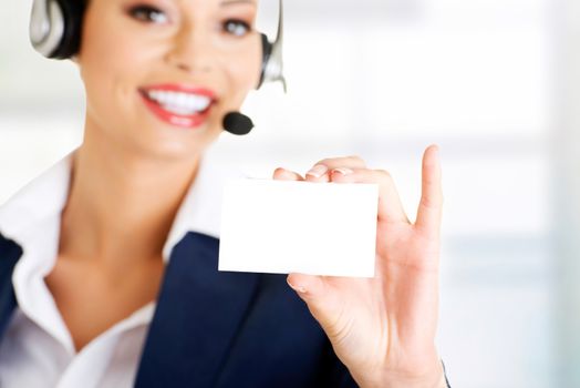 Smiling customer service representative with headset holding a blank empty card. Isolated on white background.