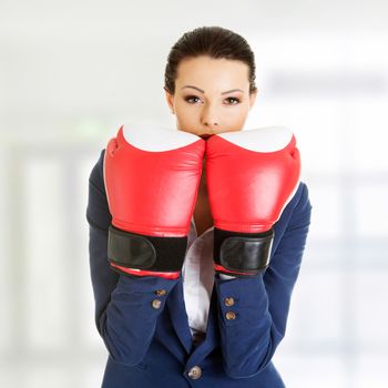 Young businesswoman with boxing gloves, isolated on white background