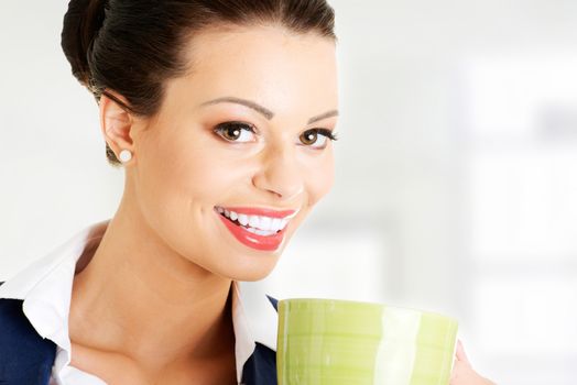 Smiling businesswoman having coffee / tea break isolated on white background