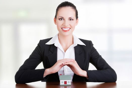 Businesswoman with house model over white - real estate loan or insurance concept