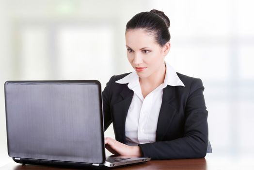 Beautiful brunette businesswoman working on laptop computer isolated on white