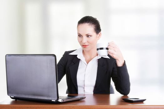 Beautiful brunette businesswoman working on laptop computer isolated on white