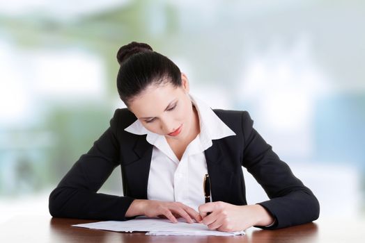 Beautiful attractive corporate lawyer business woman sitting at desk and writing blank paper page, isolated on white background.