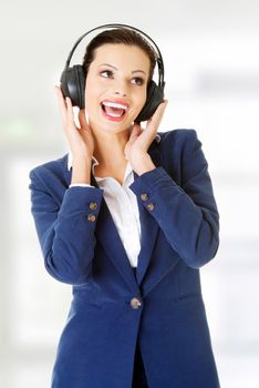 Young beautiful woman is listening to music with headphones.