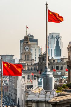 Shanghai, China - April 7, 2013: the bund rooftops and chineses flags at the city of Shanghai in China on april 7th, 2013