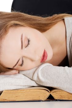 Beautiful woman is sleeping on a book. Student and education concept. Isolated on white.