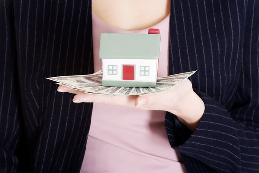 Beautiful business woman holding dollar currency and house. Close up.