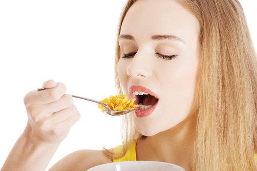 Beautiful caucasian woman eating cereals. Isolated on white.