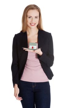 Beautiful business woman holding small house on palm. Isolated on white.