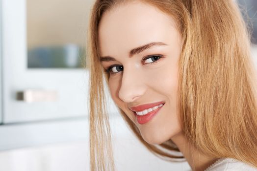 Portraif of beautiful caucasian woman standing in the kitchen.