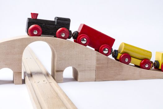 wooden toy train on bridge in grey background. horizontal image