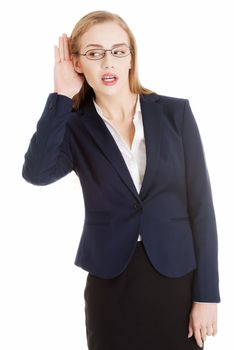 Beautiful business woman is over- hearing, trouching her ear. Isolated on white.