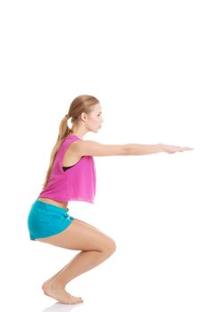 Young caucasian woman is doing exercises, wearing sportswear. Isolated on white.