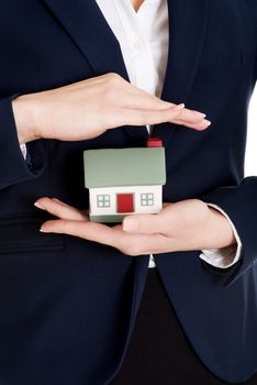 Close up on house modal in business woman's hands on belly.