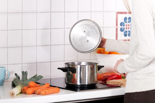 Beautiful caucasian woman is cooking. Kitchen background.