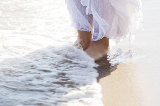 Pictore of feet on a beach and water. Over outdoor background and splashing water.
