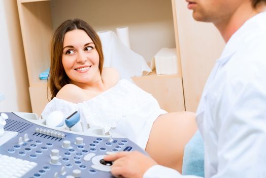 Young attractive pregnant woman on reception at the doctor, health check