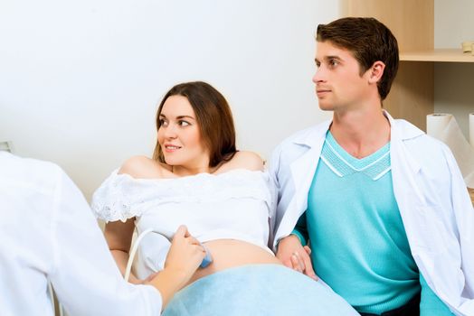 pregnant woman and the future father of the doctor's office, ultrasound diagnostics