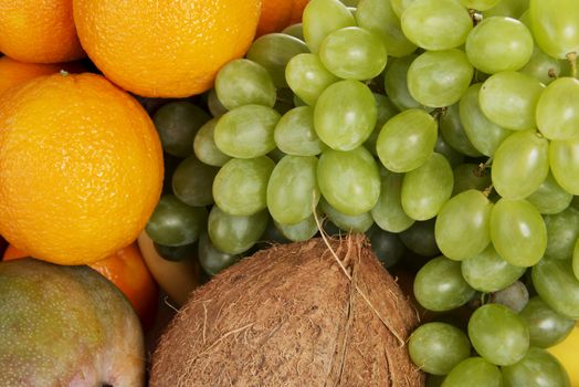 Close up on fresh fruits: mango, oranges,grapes, coconut,apples.