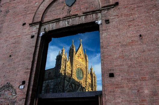 The magnificent cathedral of Siena reflected on a glass