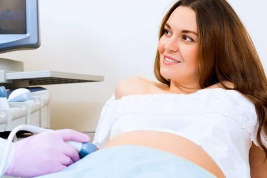 Young attractive pregnant woman on reception at the doctor, health check